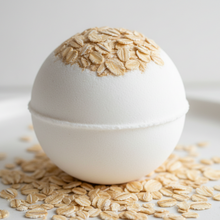 Load image into Gallery viewer, white bath bomb with oatmeal on top and sprinkled around